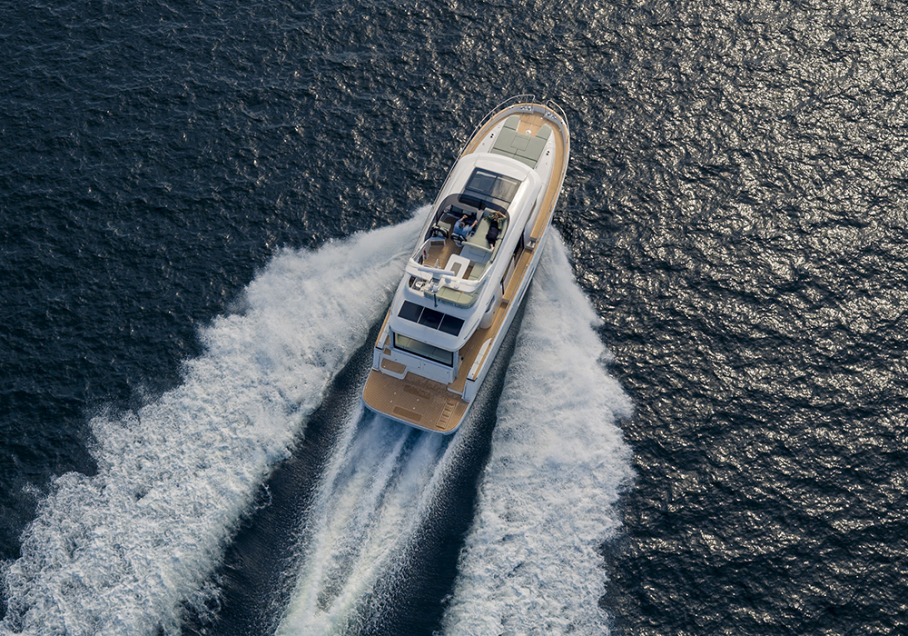 An overhead view of a boating cruising on an open body of water.