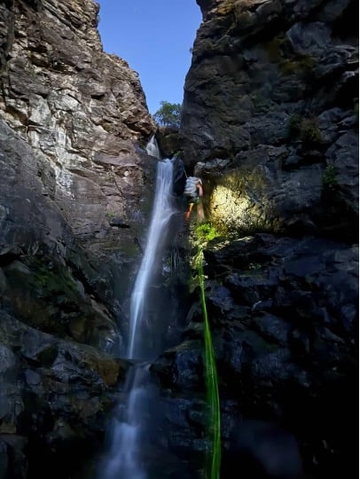 Michelle using the built-in flashlight on her fēnix 7X Pro to discern between dry and wet rock.
