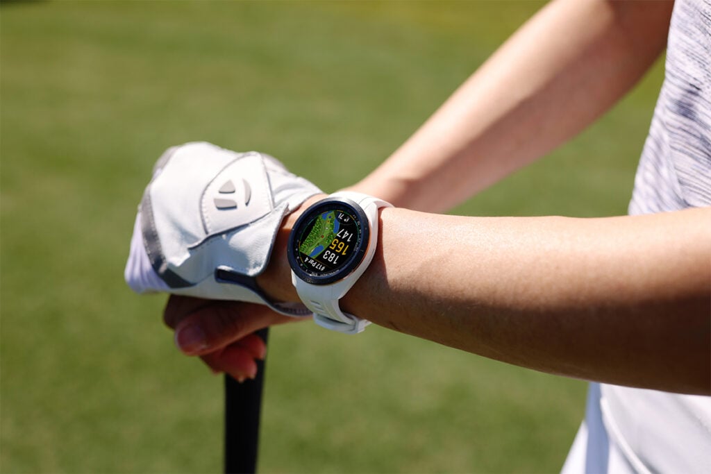 A golfer wears the Garmin Approach S70 golf smartwatch.